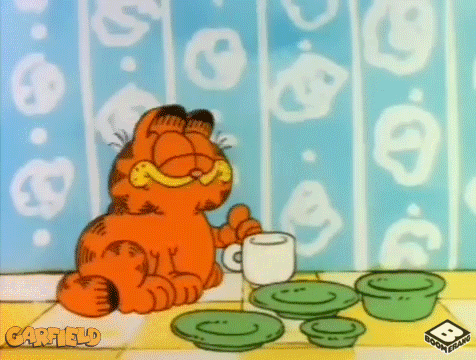 Garfield the cat drinking from a cup of coffee