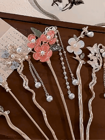 Detalle de los palitos con flores, perlas y cadenitas