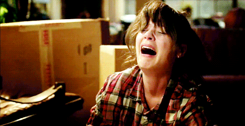 GIF of Jessica Day (Zooey Deschanel) on "New Girl" crying and wiping away tears