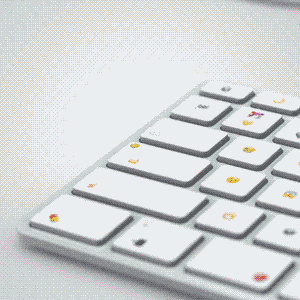 A white computer keyboard is shown with emojis instead of letters and symbols on each key.