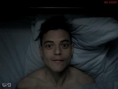 Elliot from Mr. Robot in his black hoodie at a laptop
