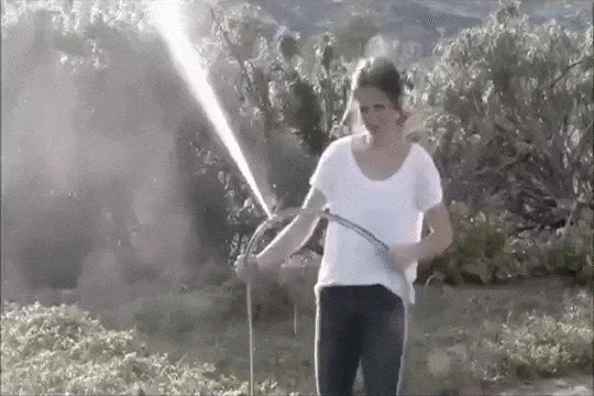 A woman fails miserably at stopping a spray leak from a torn hose