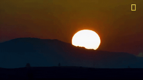 Sun rising rapidly over a mountain