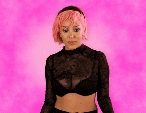 Gif of Doja Cat singing. Doja Cat is with pink short hairs. She has large golden round earrings. 