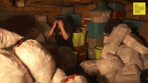 mulher dentro de um cômodo lotado de coisas acumuladas