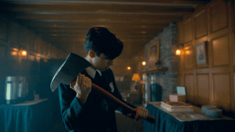 Five Hargreeves (Aiden Gallagher) holding an axe