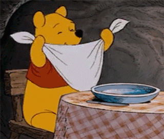 Pooh bear settling down to eat with a smug expression