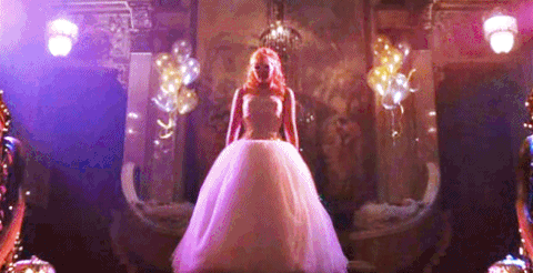 A Quinceanera celebration: a woman in a Quinceanera dress standing in front of a mirror, depicting a Cinderella story gif