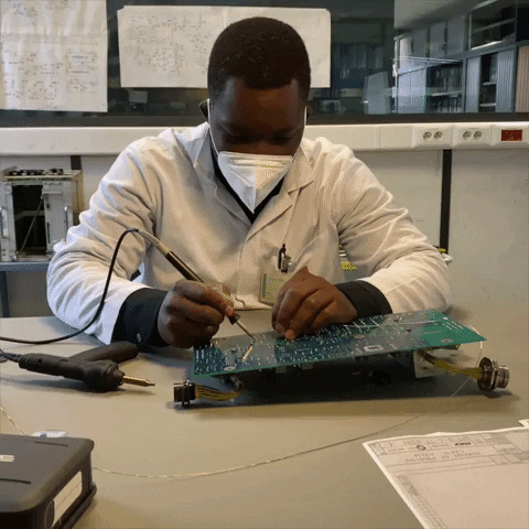 Profissional de Engenharia Elétrica realizando reparo em placa. Profissional de Engenharia Elétrica realizando reparo em placa.