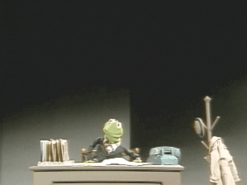 Kermit at work sitting at a desk