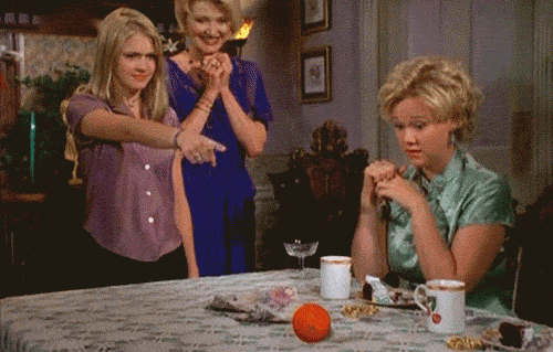 Sabrina turns an orange into a pineapple while her aunts watch.