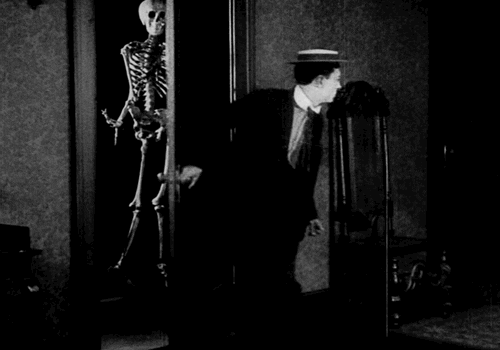 Buster Keaton opening a door with a skeleton behind it