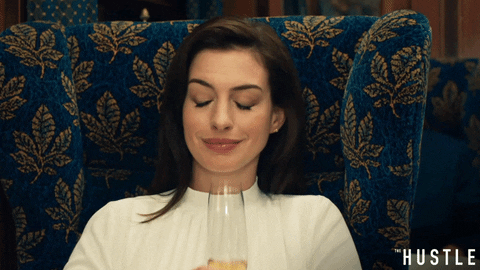 a gif of a woman toasting with a champaign 