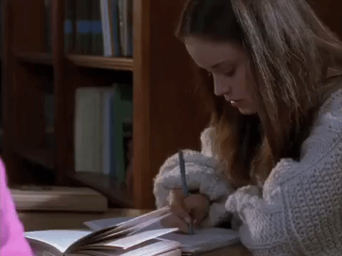 Gif de uma personagem da série Gilmore Girls escrevendo em um caderno.
