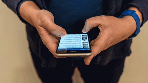 A man scrolls through various apps on a smartphone.