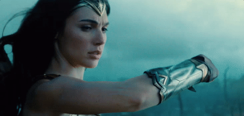 Wonder Woman blocks a bullet with her bracelet.