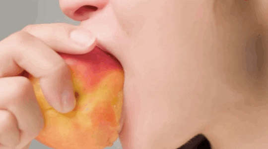 Person bites into a peach