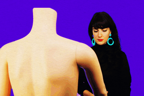 Woman shaking hands with a mannequin 