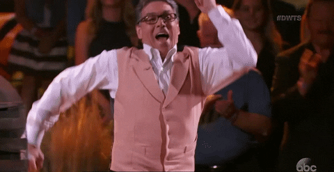 Rick Perry dances in a white shirt and pink vest.