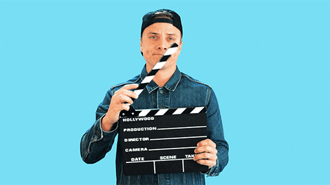 Young man with a clapperboard saying 