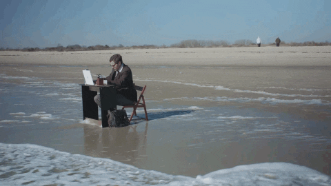 Man Studying at Desk at the Beach