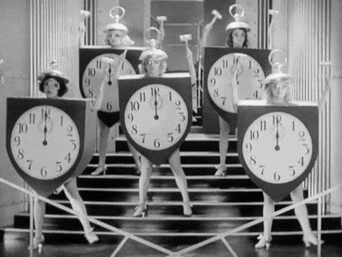 Mujeres vestidas de relojes gigantes bailando