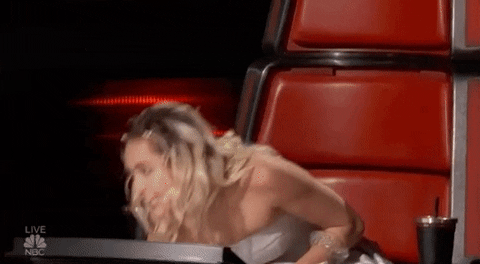 Blond Miley Cyrus, a woman in a white dress sitting on a red chair for a Quinceanera