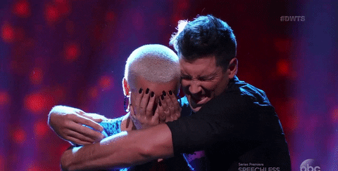 Amber Rose being hugged on stage by her partner. 
