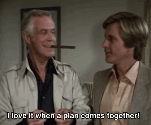 Two men in a group of four telling each other that they love it when a plan comes together via giphy.com