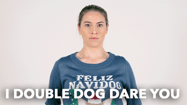 gif of woman double-dog daring...with two black terriers wearing Santa hats