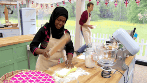 Black woman in hijab pounding dough for baking