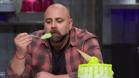 Duff Goldman taking a big bite of cake.