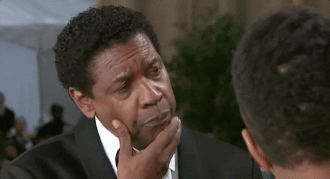 Denzel Washington scratching his chin while being asked a question