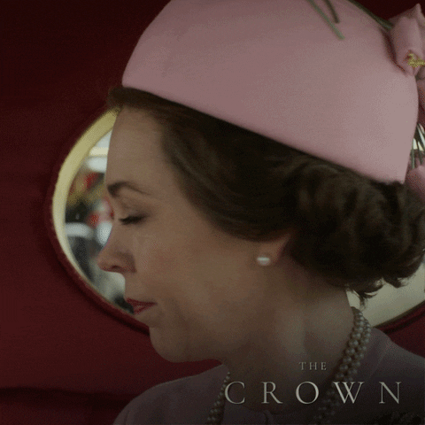A atriz Olivia Colman interpretou a Rainha Elizabeth II na terceira e quarta temporada da série. No gif, ela vai de encontro ao evento de comemoração do seu Jubileu de Prata. Ela está dentro da carruagem com um vestido e chapéu rosa pastel e um colar de pérolas. Comece a maratona e treine o inglês com a série The Crown.