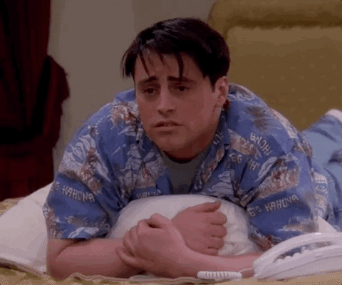 A GIF of Joey Tribbiani lying down on a bed while starting to cry as the camera zooms in on him.
