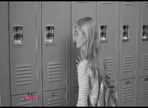 GIF: A friendless loser waving at people as they walk by her at the lockers, but they ignore her.