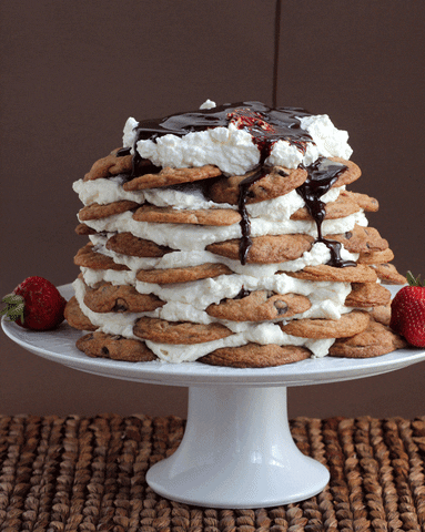uma pilha de cookies com sorvete e cobertos de chocolate