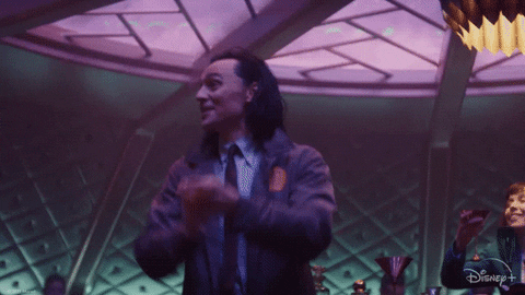 Loki (Tom Hiddleston) clapping and celebrating at a bar