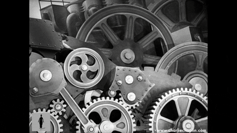 Animated image of Charlie Chaplin fixing gears in a factory.