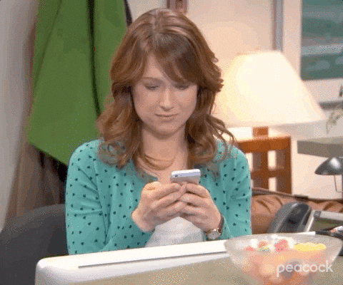 A gif of Erin from The Office texting on her phone