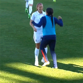 women on opposite soccer teams with secret handshake