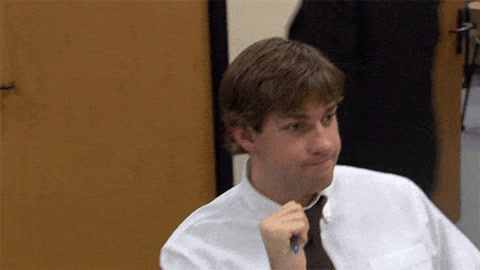 The Office: Jim Halpert at his desk pinches his fingers together, so close, then shrugs at the camera
