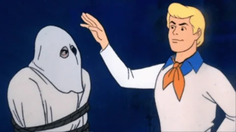 Fred from Scooby-Doo pulls the mask off the villain