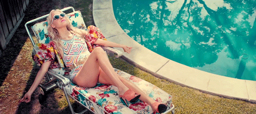 Une femme prend un bain de soleil au bord de la piscine, l'un des mauvais cheveux de l'été