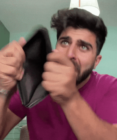 Man turning an empty wallet inside out and looking at the camera
