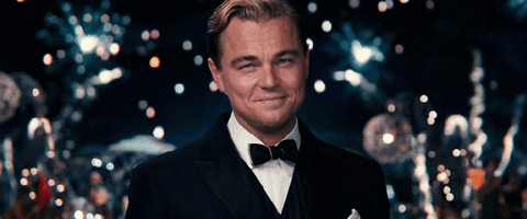 GIF of Leonardo Di Caprio cheering with fireworks flashing in the background