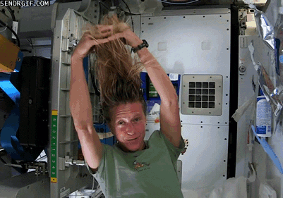 Gif d'une femme qui se coiffe dans une station spatiale