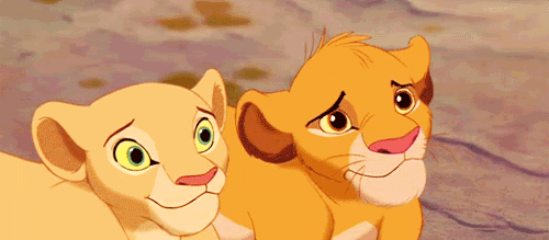 Lion cubs Simba and Nala smile simultaneously, revealing sharp, white teeth.