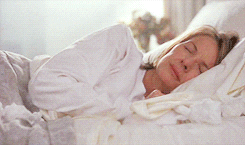 Gif of an older woman crying in her bed.