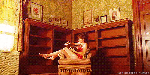 como se dar bem no enem: gif de uma menina sentada lendo um livro e a estante, atrás, se enchendo de livros.